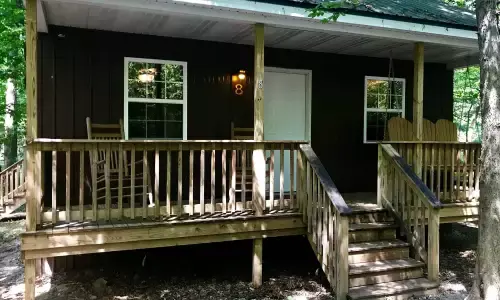The exterior of a cabin surrounded by trees