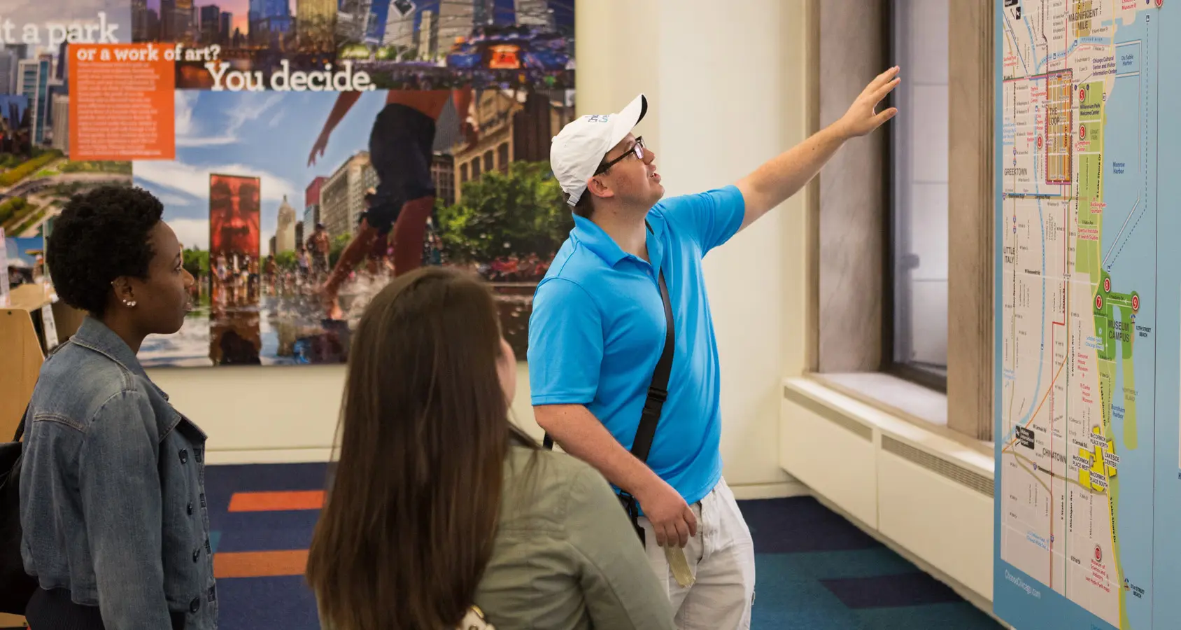 A Chicago Greeter talks to visitors in a visitor center.