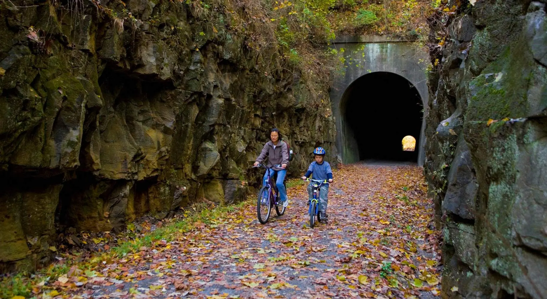 Two people biking through a tunnel